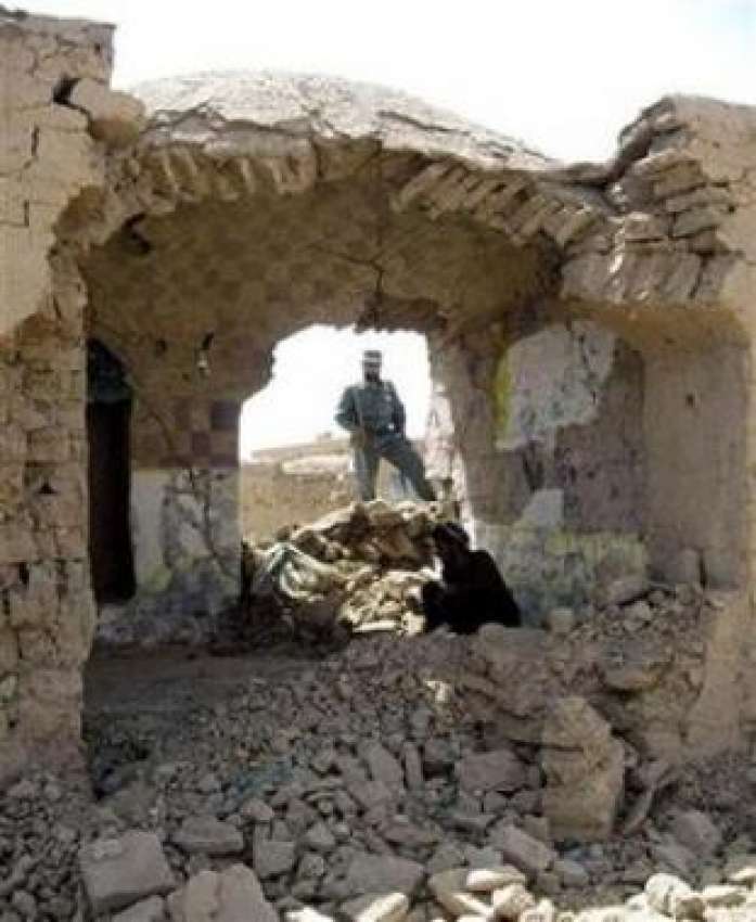 افغانستان، ایک افغان سکیورٹی اہلکار تباہ شدہ گھر کے ملبے ..