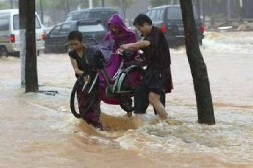 چین: شدید بارشوں کے باعث آنے والے سیلاب کے پانی میں سے لوگ ..