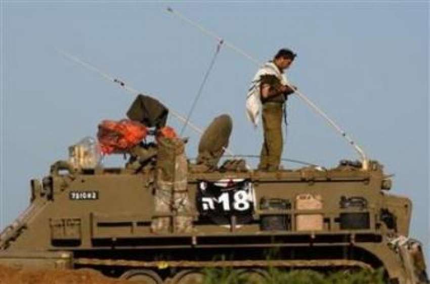 غزہ،ایک اسرائیلی فوجی غزہ شہر کے مرکز میں اپنے ٹینک پر کھڑا ..