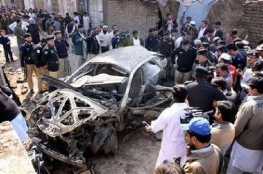 پشاور: پولیس اہلکار بم دھماکے میں تباہ ہونے والی گاڑی کو ..