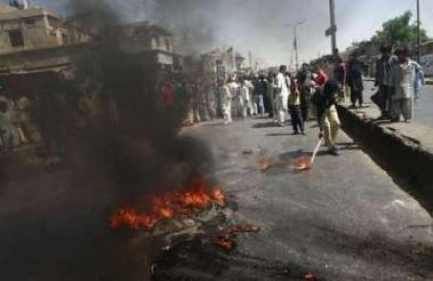 کراچی،ایک پولیس اہلکار مشتعل مظاہرین کی جانب سے بلوچ رہنمائوں ..