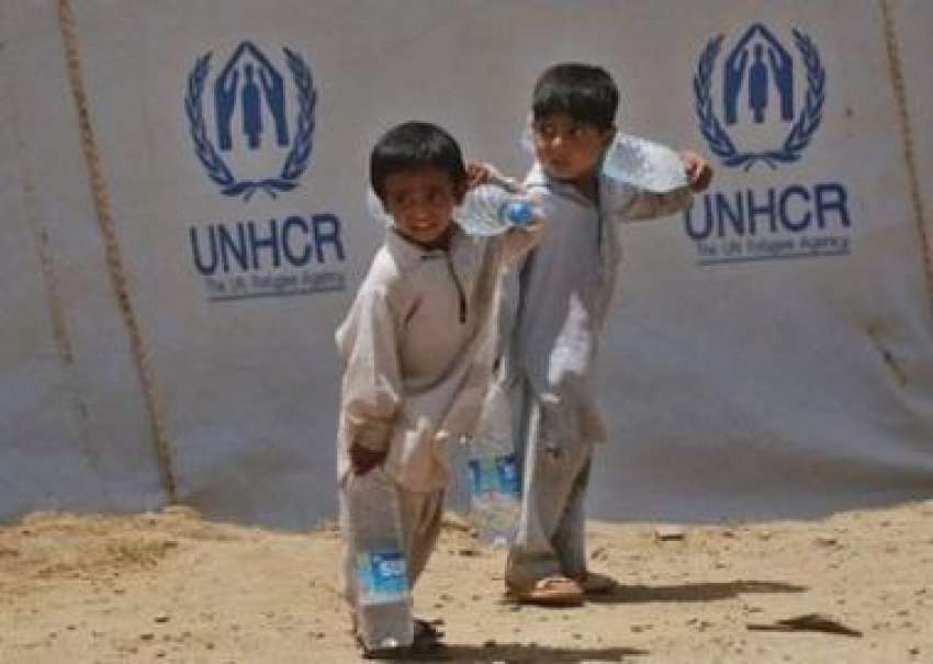 مردان،ایک مہاجر کیمپ میں بچے پانی کی بوتلیں اپنے خاندان ..