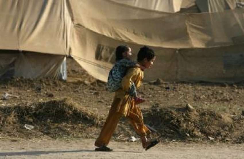 صوابی،یارحسین مہاجر کیمپ میں ایک بچہ اپنی بہن کو کندھے پر ..