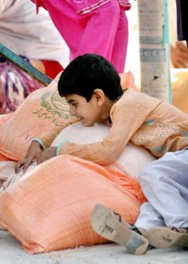 راولپنڈی،ایک بچہ سستا بازار سے خریدے گئے آٹے کے تھیلوں‌کے ..