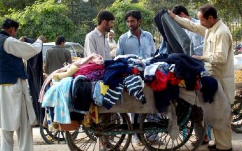 راولپنڈی، لوگ ریڑھی سے گرم کپڑے خرید رہے ہیں۔