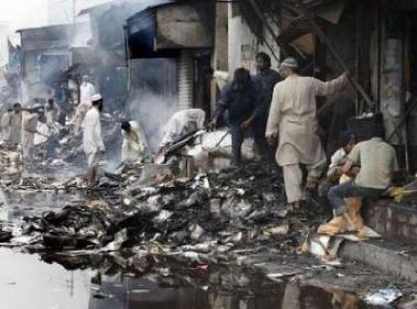کراچی،دکاندار کل ہونیوالے خودکش حملے کے بعد جلنے والی مارکیٹ ..