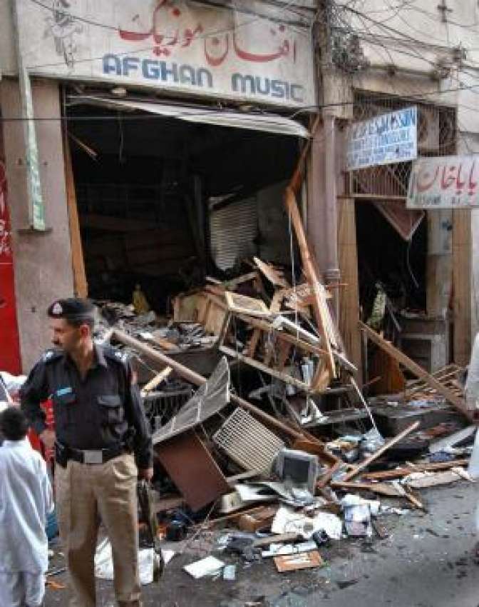 پشاور،سی‌ڈی مارکیٹ میں بم دھماکے کے بعد ایک پولیس اہلکار ..