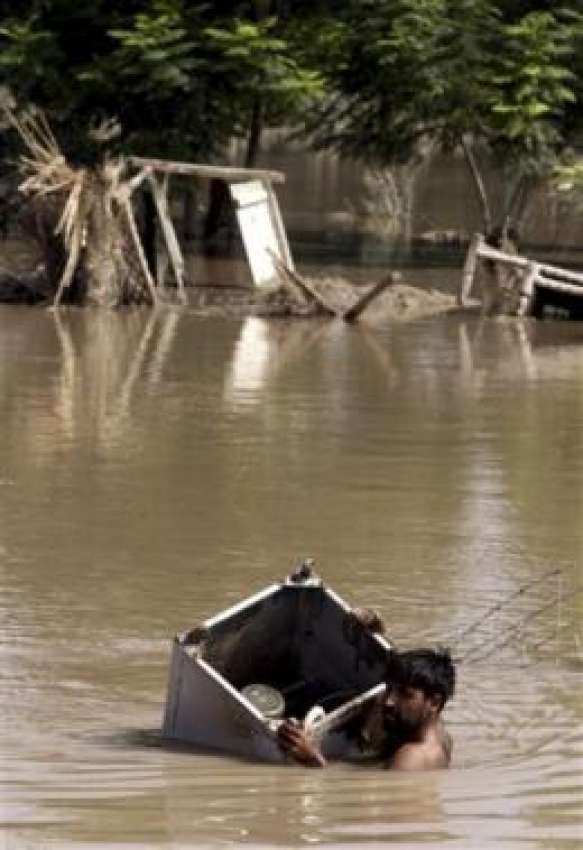 پشاور،سیلاب سے متاثرہ علاقہ میں ایک شخص واشنگ مشین کے ذریعے ..
