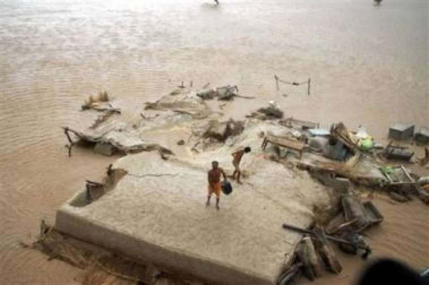ملتان،سیلاب سے متاثرہ ایک گائوں‌میں شہری اپنے گھر کی چھت ..