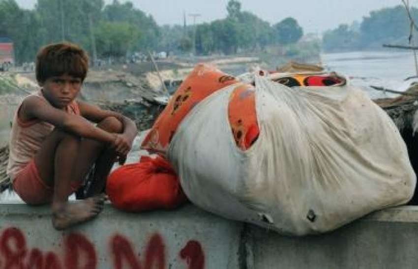 سکھر،سیلاب سے متاثرہ ایک بچہ اپنا سامان لئے نقل مکانی کا ..