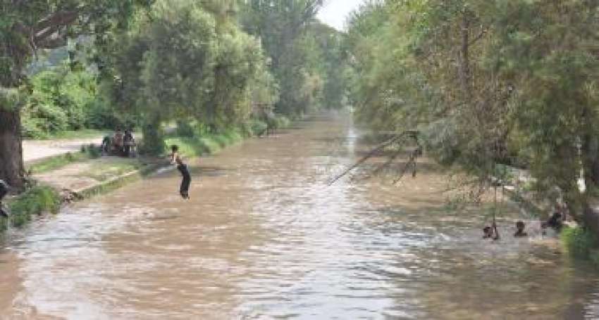 لاہور، گرمی کی شدت کم کرنے کیلئے بچے نہر میں‌ نہا رہے ہیں۔ ..