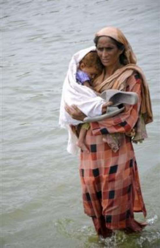مظفر گڑھ: سیلاب سے متاثرہ عورت اپنے بچے کو اٹھائے محفوظ مقام ..