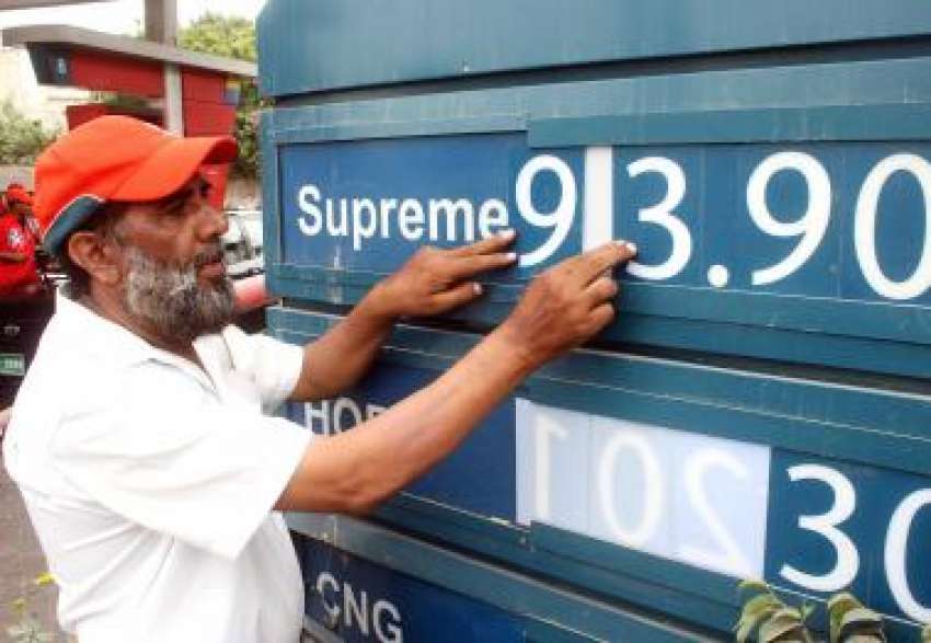 کراچی، ایک مقامی پیٹرول پمپ کا اہلکار پیٹرولیم کی نئی قیمتیں ..