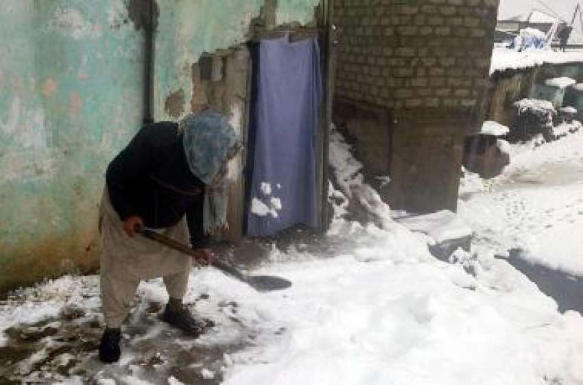 بٹگرام، ایک شخص شدید برفباری کے بعد اپنے گھر کے سامنے جمع ..