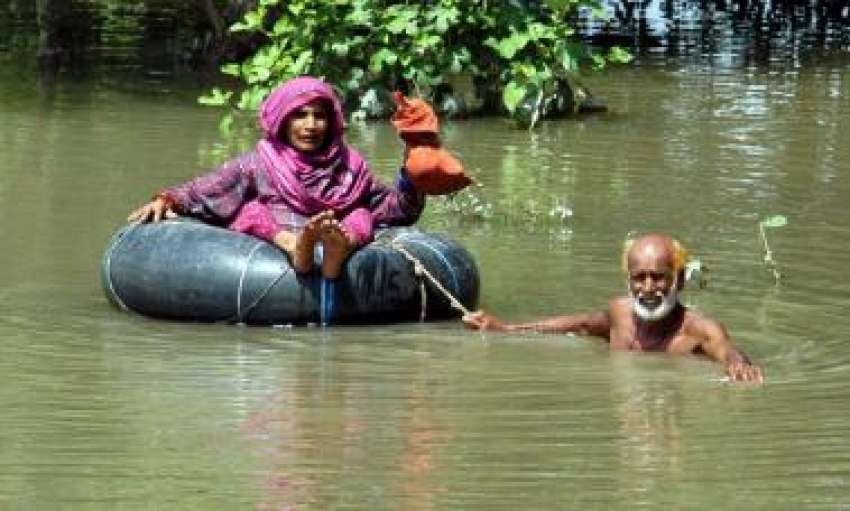 ملتان، سیلاب متاثرہ علاقہ میں ایک معمر شخص اپنے اہلیہ کے ..