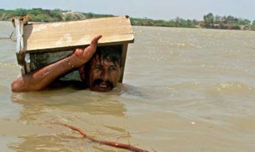 حیدر آباد، ایک شخص سیلابی پانی سے محفوظ مقام پر جا رہا ہے۔