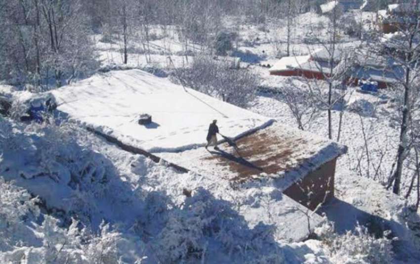 پوٹھی مکو الاں: برفباری کے بعد ایک شخص اپنے مکان کی چھت سے ..