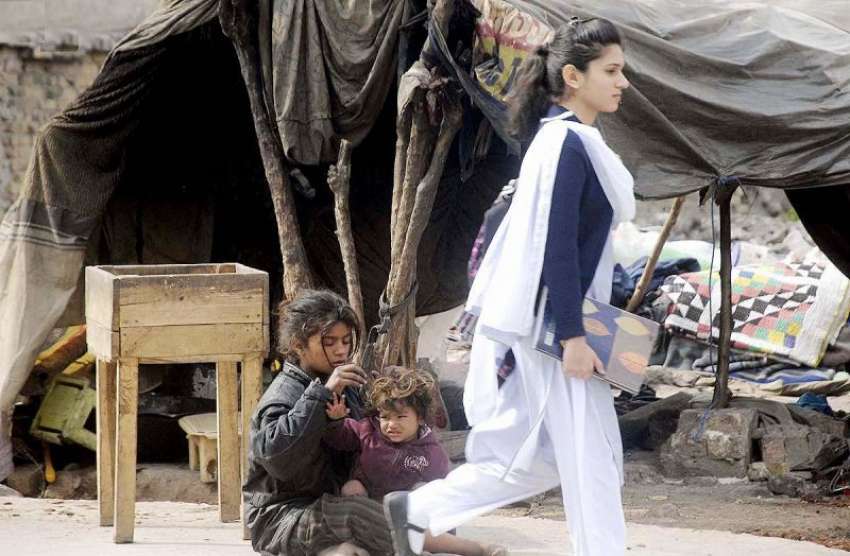 راولپنڈی: مستقبل سے بے خبر خانہ بدوش بچیاں اپنی جھگی کے باہر ..