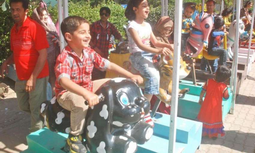 لاہور ، ہفتہ وار تعطیل کے موقع پر بچے مقامی پارک میں‌جھولے ..