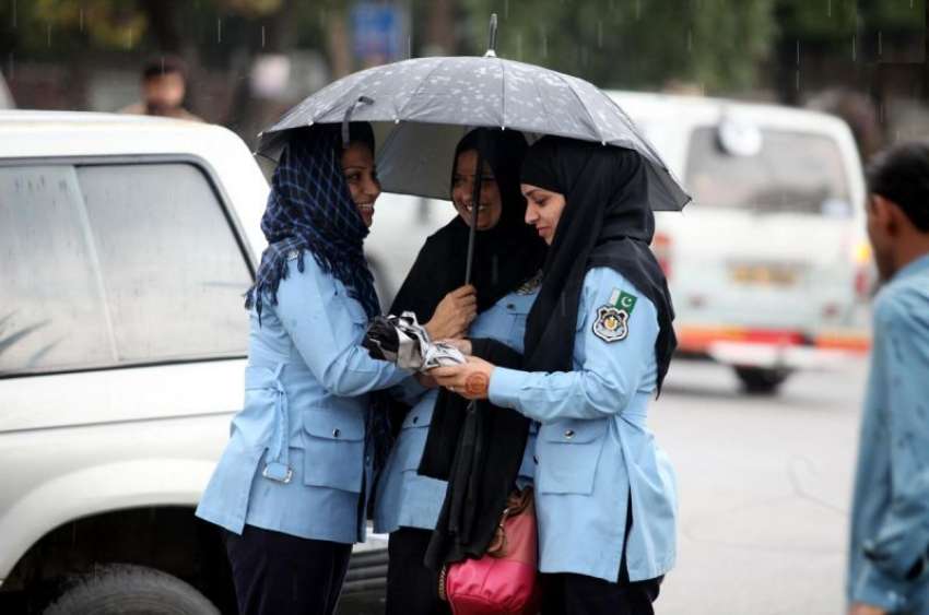 اسلام آباد: خاتون پولیس اہلکار بارش میں چھتری تانے خوش گپیوں ..