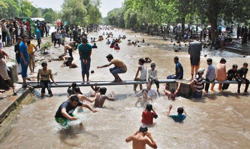 لاہور، گرمی کی شدت کم کرنے کیلئے شہری نہر میں نہا رہے ہیں۔