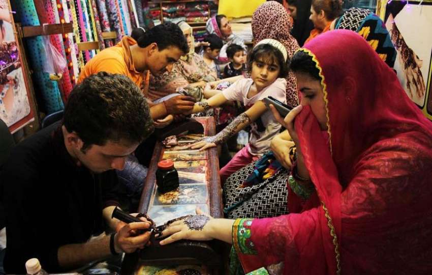لاہور:عید کی آمد کے موقع پر خواتین اپنے ہاتھوں پر مہندی لگوا ..