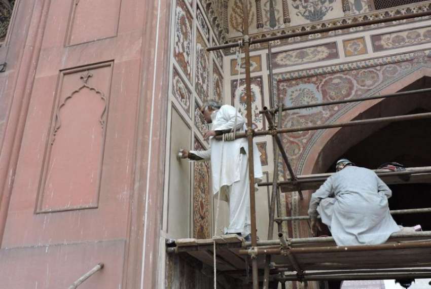لاہور، مزدور بادشاہی مسجد کے مرکزی دروازے پر تزین و آرائش ..