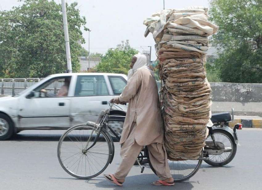 لاہور: ایک محنت کش شدید گرمی میں سیمنٹ کے خالی تھیلے سائیکل ..