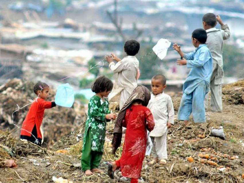 راولپنڈی: کچی بستی میں بچے شاپنگ بیگ کو پتنگ بنا کر ہوا میں ..