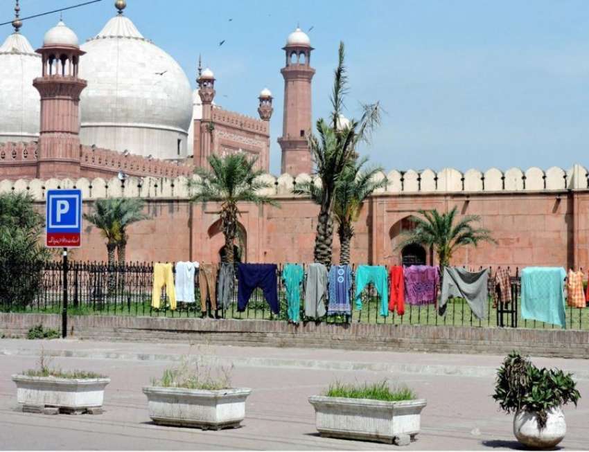 لاہور: بادشاہی مسجد کے باہر جنگلے پر شہری نے کپڑے خشک کرنے ..
