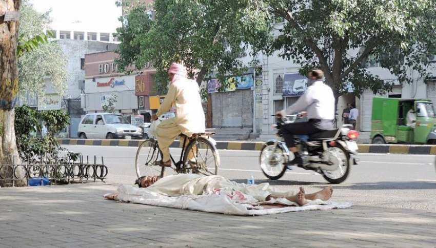 لاہور: ایک بے گھر شخص مال روڈ فٹ پاتھ پر سو رہا ہے۔
