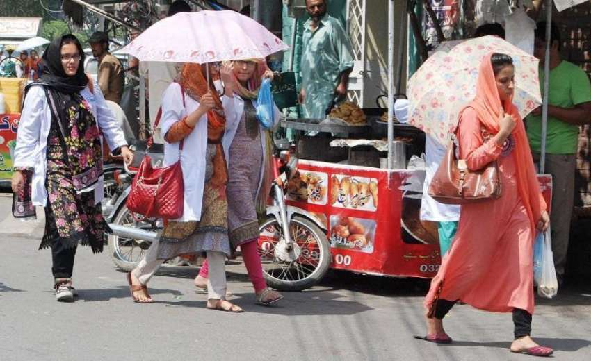 لاہور: طالبات تیز دھوپ سے بچنے کے لیے چھتریاں تانے جا رہی ..