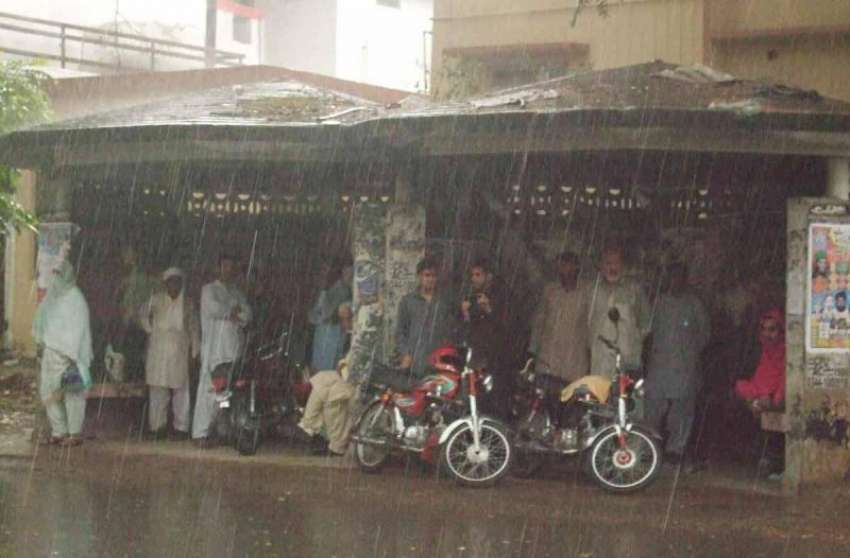 اسلام آباد: تیز بارش سے بچنے کے لیے شہری سٹاپ پر بنے شیڈ کے ..