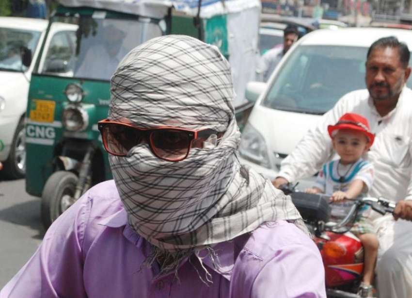 لاہور: ایک موٹرسائیکل سوار دوپہر کے وقت شدید گرمی میں لُو ..