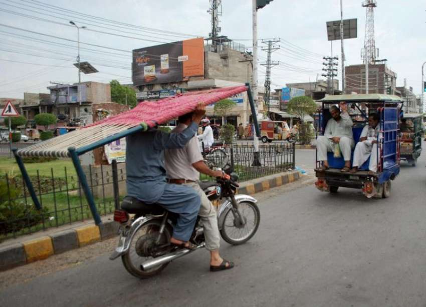 لاہور: شہری موٹر سائیکل پر چارپائی لے کر جا رہے ہیں۔