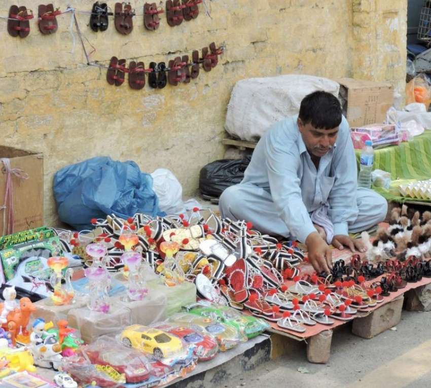 لاہور: بادشاہی مسجد کے قریب ایک شخص نے جوتوں کا سٹال سجا ..