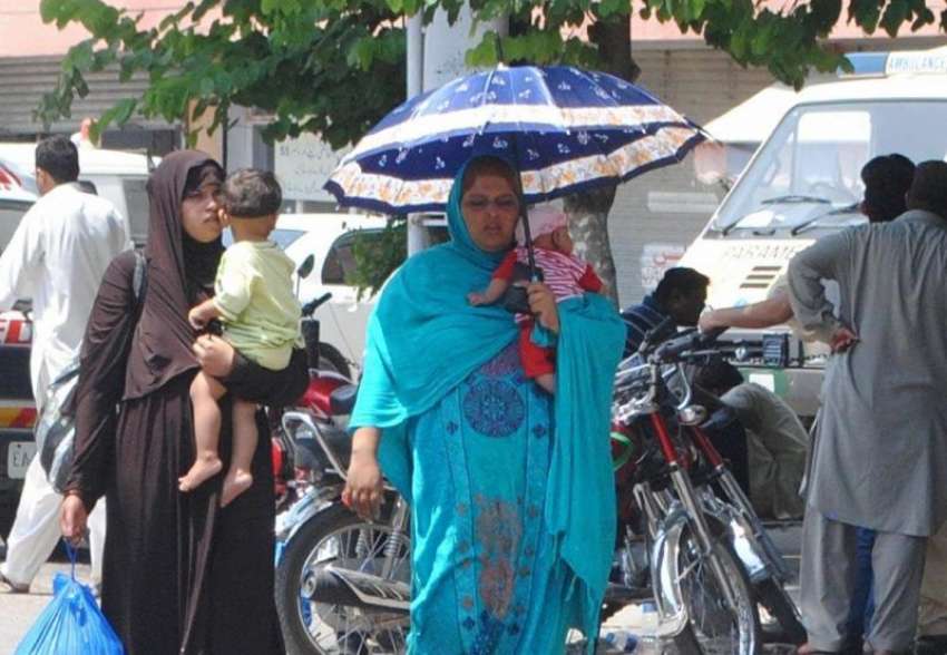 راولپنڈی: دھوپ کی شدت کو کم کرنے کے لیے خواتین چھتری تھامے ..