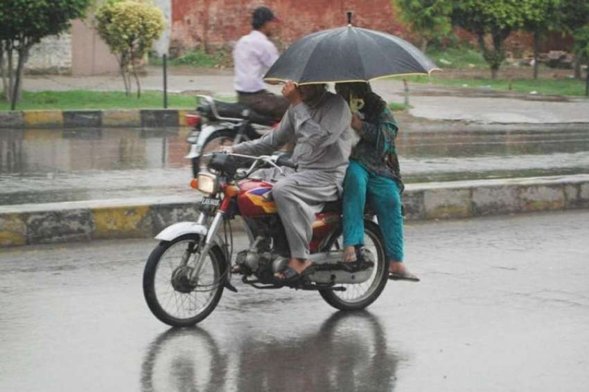 لاہور: شہر میں ہونے والی تیز بارش کے دوران ایک موٹر سائیکل ..