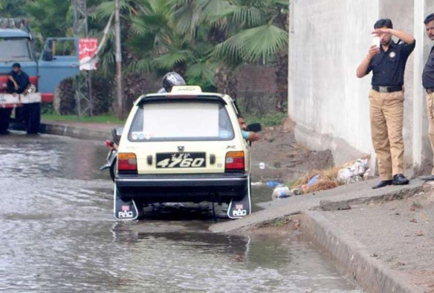 راولپنڈی: بارش کے دوران ایک پولیس اہلکار اپنے موبائل سے ..