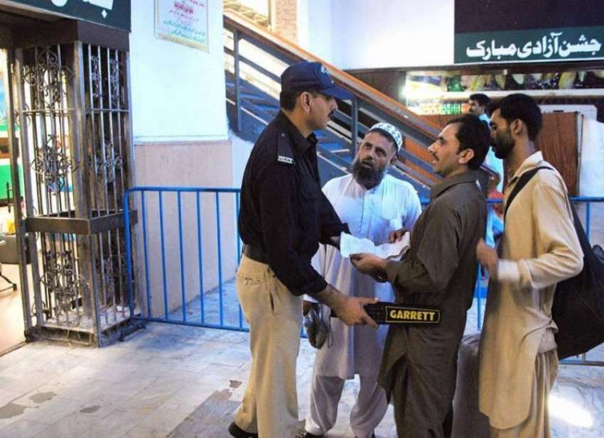 لاہور: ریلوے اسٹیشن پر ایک پولیس اہلکار مسافروں کی تلاشی ..