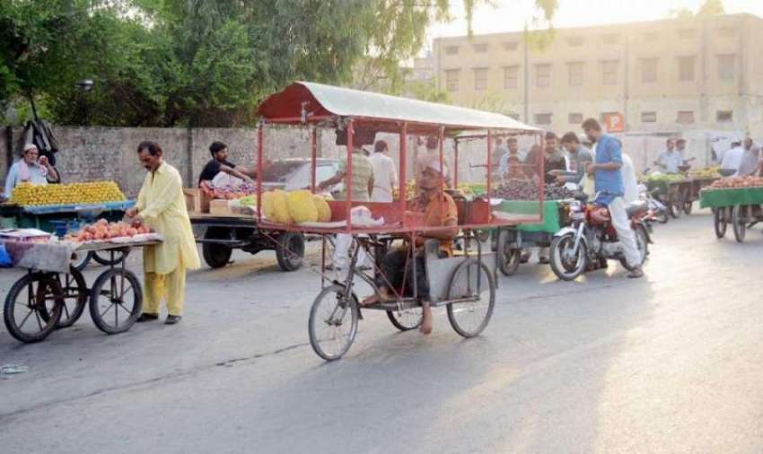 فیصل آباد: کوتوالی روڈ پر ایک معذور شخص اپنی ویل چیئر سائیکل ..