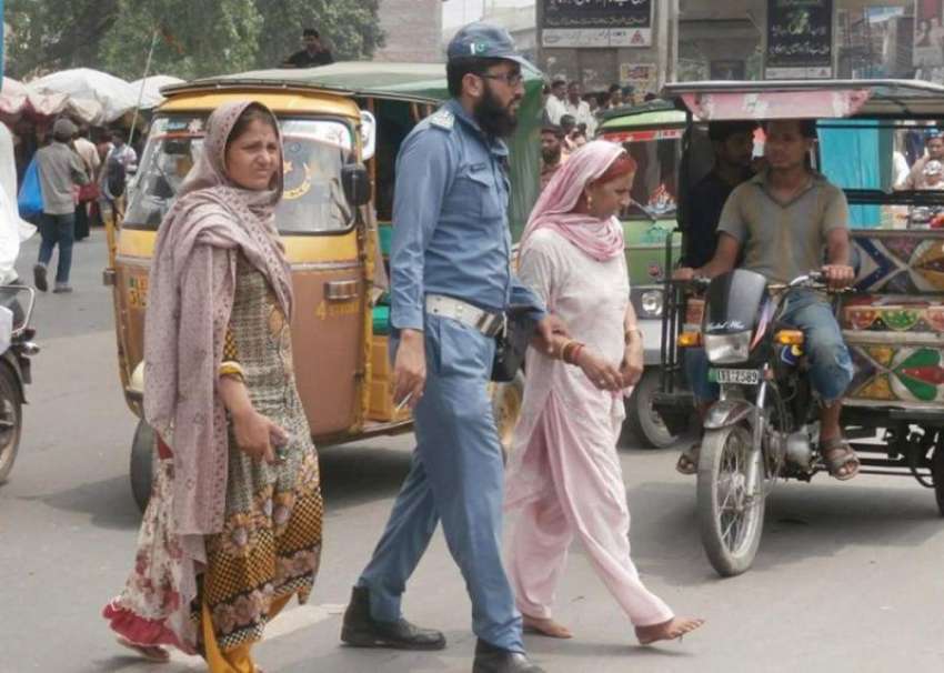لاہور: ٹریفک واڈن سڑک عبور کرنے میں خواتین کی مدد کر رہا ..