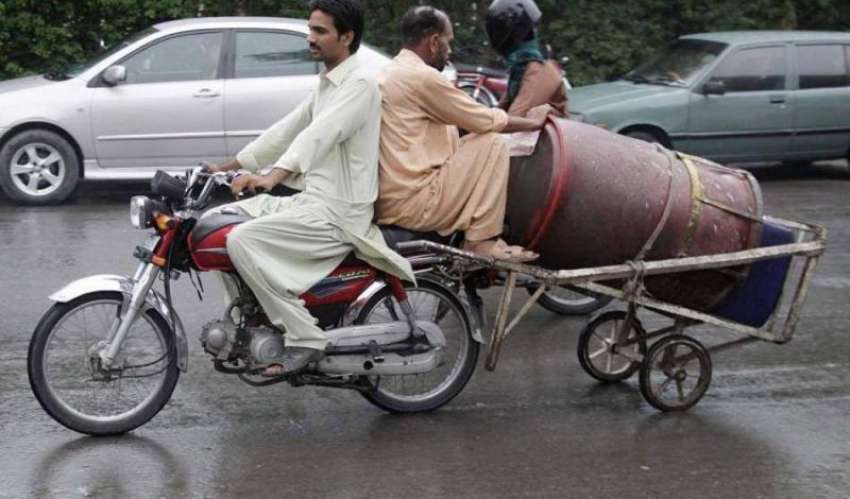 لاہور: دو شخص موٹر سائیکل کے پیچھے ہتھ ریڑھی باندھے اس پر ..