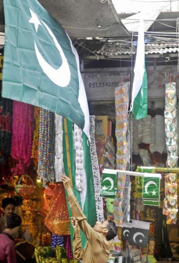 راولپنڈی: 14اگست کے حوالے سے ایک دکاندار پاکستانی پرچم سجا ..
