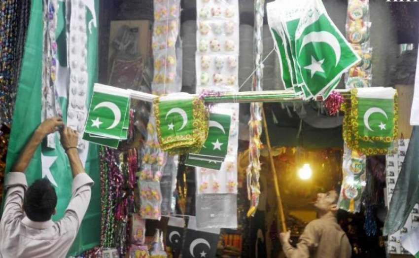 راولپنڈی: 14اگست کی تیاریوں کے حوالے سے ایک دکاندارپرچم سجا ..