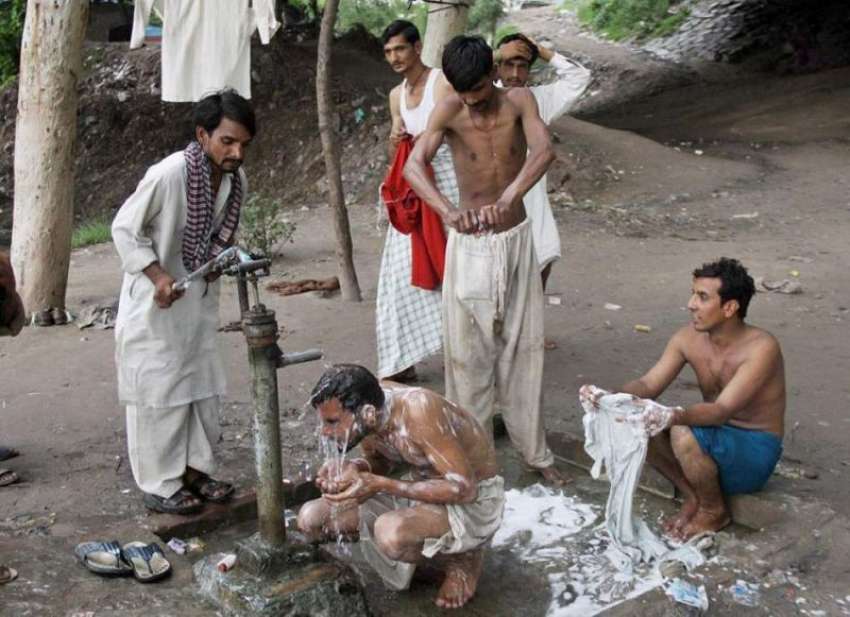 لاہور: نواحی علاقہ میں گرمی کے ستائے لوگ ہینڈ پمپ کے نیچے ..