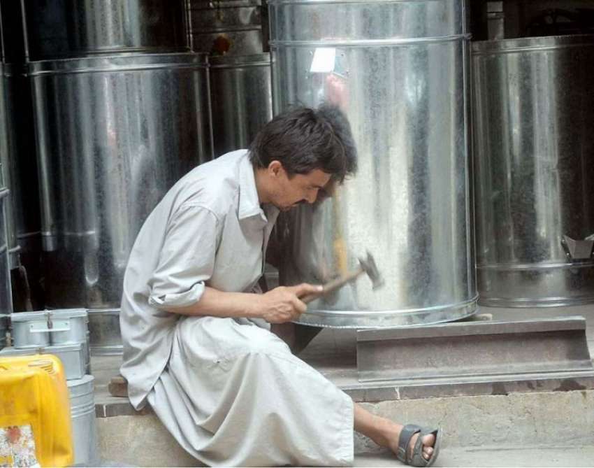 کوئٹہ: قنداھاری بازار میں ایک دکاندار اپنی دکان میں پانی ..