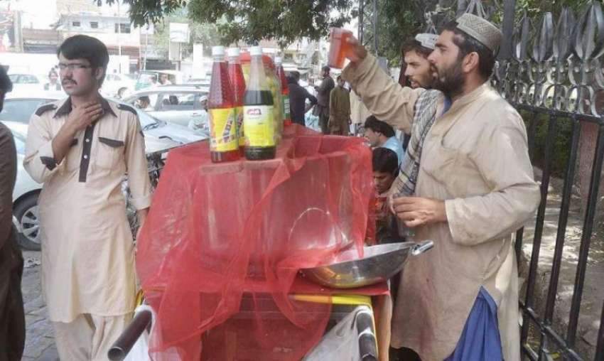 کوئٹہ: سرکلر روڈ کے کارنر پر ایک شخص گاہکوں کے لیے گرمی سے ..
