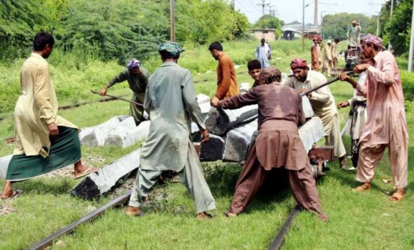 لاہور: ریلوے مزدور ٹریک کے درمیان ڈالنے کے لیے لائی گئی سلیپیں ..