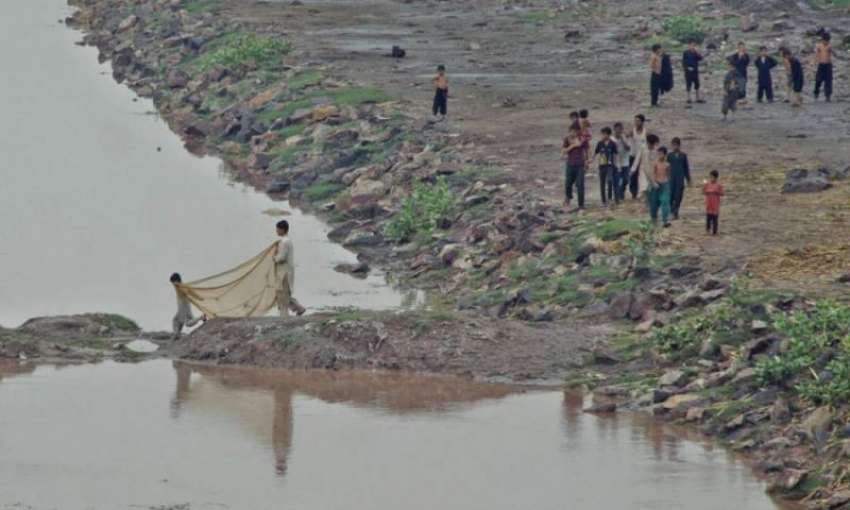 لاہور: بچے دریائے راو ی سے مچھلیاں پکڑ رہے ہیں۔